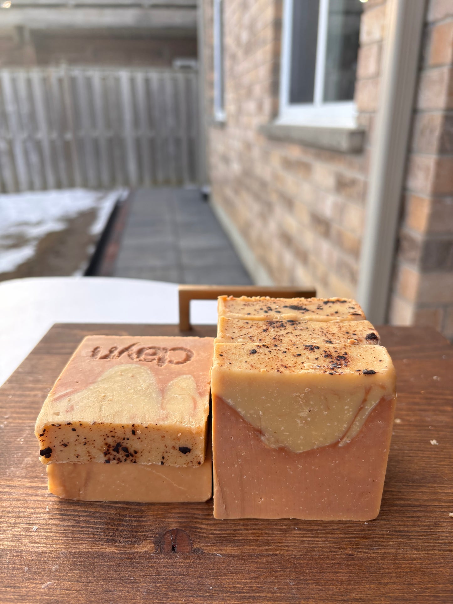 Two soap bars on a wooden block with 'Kep' branding, outdoors.