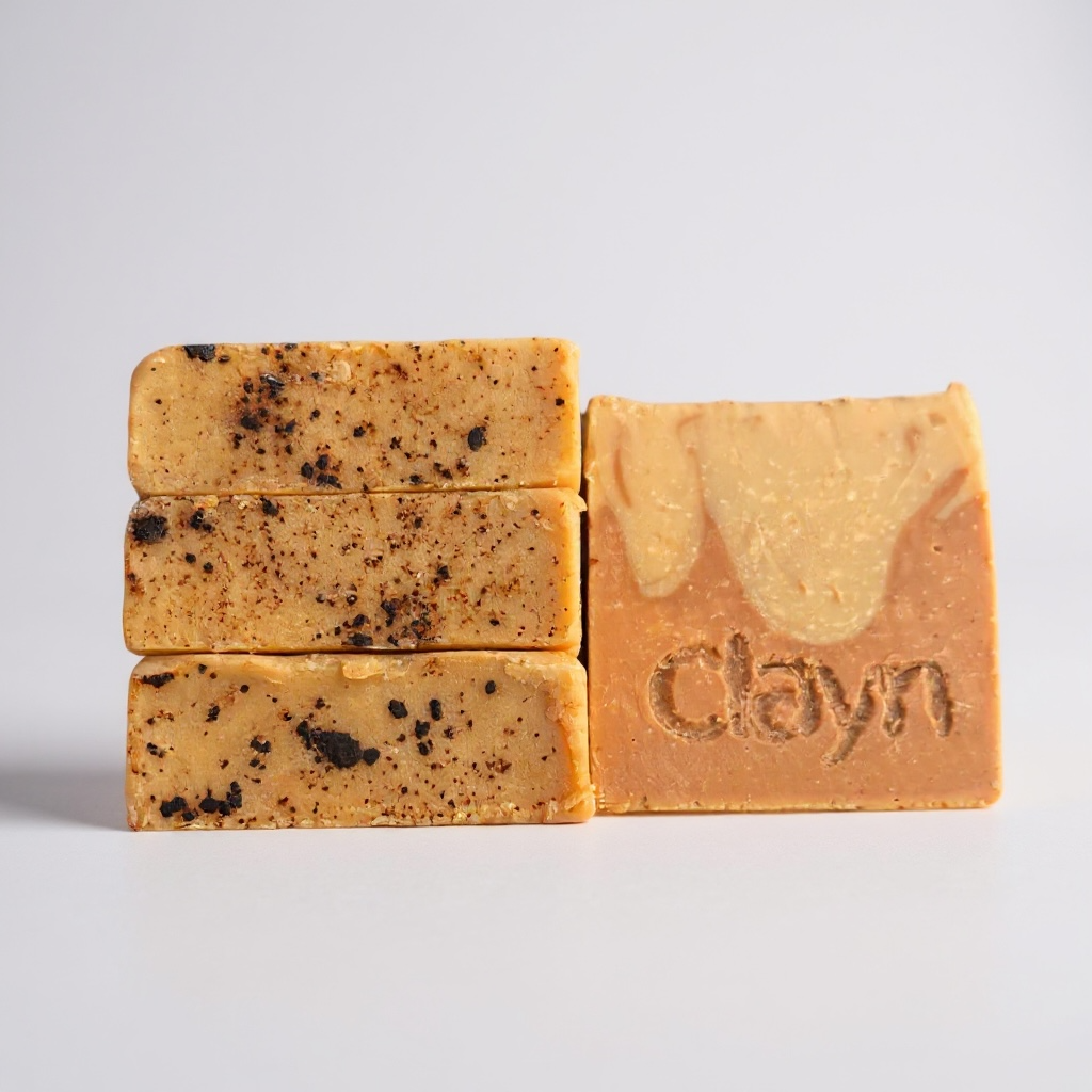 Three bars of soap with visible texture and 'Clayn' branding on a light gray background
