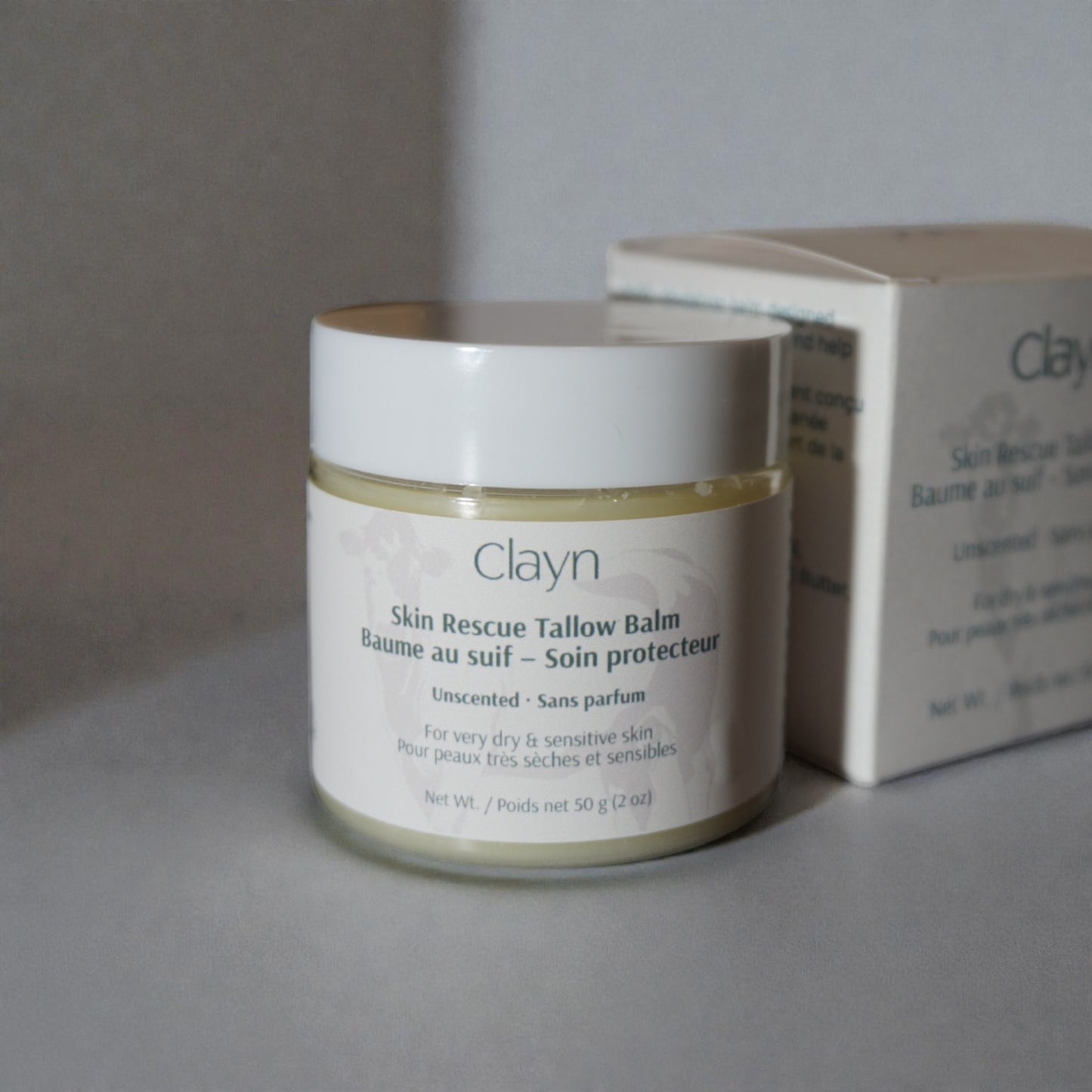Clayn Skin Rescue Tallow Balm jar with a box on a neutral background
